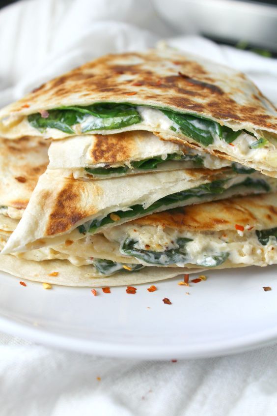 Two favorite snacks are combined into one with these Vegan Spinach Artichoke Quesadillas. These are ooey, gooey and super delicious | ThisSavoryVegan.com