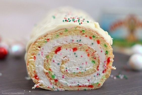A simple vanilla roll cake with red and green dots and spirals of creamy buttercream is the perfect dessert for Christmas parties.